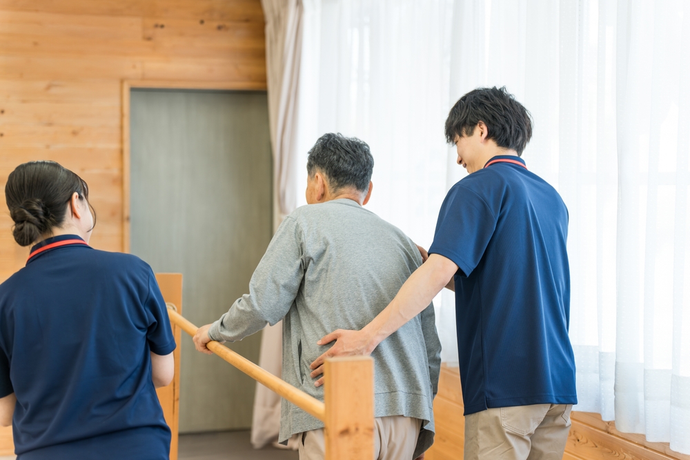 Senior,Man,Using,Handrails,For,Walking,Training,,Accompanied,By,An